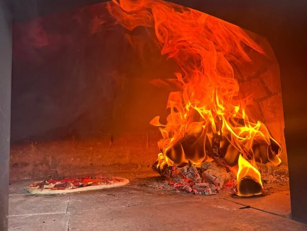 Pizza cooking in our wood-fired oven